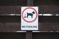 No dog fouling sign on wooden park fence