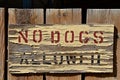 A NO DOGS ALLOWED sign is weathered and peeling. Royalty Free Stock Photo