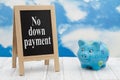 No down payment message standing chalkboard with a piggy bank with clear sky