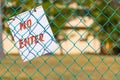 No Enter sign on green fence close up outdoors