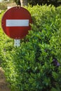 No entry or Do not enter traffic sign overgrown in green flowering hedge Royalty Free Stock Photo