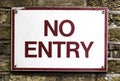 No entry red and white sign on brick wall