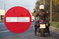 No entry sign and motorcyclist standing by the roadside, collage