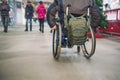 No face aged disabled, handicapped person on wheeled chair among people without disabilities in the mall of market place. Selectiv