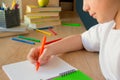 No face shot of a child boy writing in his copybook, doing homework at home. Faceless concept Royalty Free Stock Photo
