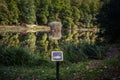 No fishing sign in front of a Panorama of the pond Jankovac, a small water lake surrounded by trees and forest in the Papuk