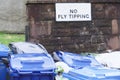 No fly tipping sign and rubbish bins at council estate