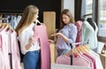 Pretty shopper showing her friend dislike with gesture