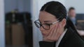 No ideas, unmotivated business woman with glasses thinks while working in office close-up