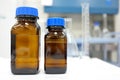 No label amber glass bottle with clear liquid chemical inside a laboratory with copy space.