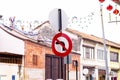 No left turn sign broken, distorted damaged there is buildings and white sky are background. Royalty Free Stock Photo