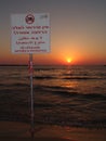 No lifeguard, swimming prohibited sign on a Tel Aviv beach at warm, summer sunset Royalty Free Stock Photo