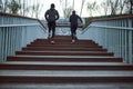 No limits. Back view of a couple in black sportswear running up stairs outdoors. People jogging in the morning in park Royalty Free Stock Photo