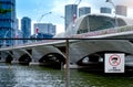 No littering sign on wire fence beside the river in downtown with skyscraper business building. Signs for not throwing garbage Royalty Free Stock Photo