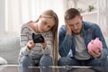 Stressed millennial couple counting last money at home