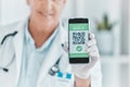 No more messy paperwork. a male doctor holding a smartphone depicting a QR code to be scanned.