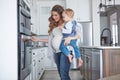 No one can juggle like a mom does. a pregnant woman baking while spending spending time with her toddler son at home. Royalty Free Stock Photo