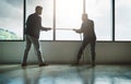 No one pushes you to achieve more than your competitor. two young businessmen pulling on a rope in a game of tug of war.