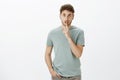No one should no, keep mouth shut. Portrait of charming confident european man in t-shirt, saying shh while showing