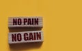 No Pain No Gain message written with wooden blocks on yellow. Business success concept Royalty Free Stock Photo