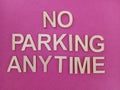 No parking anytime sign on a pink background