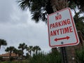 No parking anytime sign by trees at street