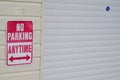 No parking anytime sign on the wall building garage