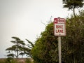 No parking bike lane sign post hanging around trees on a street Royalty Free Stock Photo