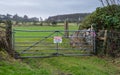 No Parking Farm vehicle access required 24 hours sign on a farm gate at a field