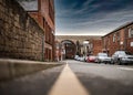 No parking restrictions yellow line on road low angle showing cars parked on busy town street scene. Railway arches bridge shops. Royalty Free Stock Photo