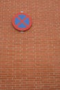 No parking sign on a red brick wall, in Madrid Spain