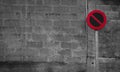 No parking sign. Regulatory sign. Circle red and black no parking sign on post. Traffic sign on gray and white brick wall texture