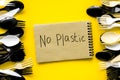 No plastic copy. Eco concept and injunction on the use of plastic flatware on yellow background top view