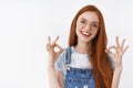No problem, everything ok. Cheerful optimistic redhead european girl wear glasses show okay approval sign smiling