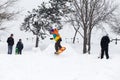 Kid jumping over a hill made of snow with snowboard Royalty Free Stock Photo