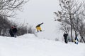 Kid jumping over a hill made of snow with snowboard Royalty Free Stock Photo