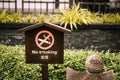 No smoking label put on wooden plate and garden background