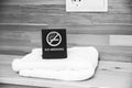 No smoking sign on the bedside table. Hotel towels Royalty Free Stock Photo