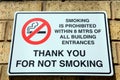 No smoking sign on a brick wall.