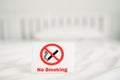 No smoking sign on white cleaned bed in  hotel`s bedroom Royalty Free Stock Photo