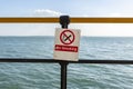 No Smoking Warning Sign in front of blue sea.