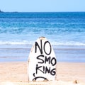 No Smoking warning sign on white surfboard at the beach in summer, concept of sea environmantal protection design, copy space,