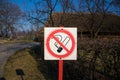 No smoking white red sign on post in public place, park. Crossed out cigarette. Royalty Free Stock Photo