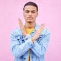 No, stop and portrait of a man with hands as a sign isolated on a pink studio background. Angry, caution and serious