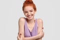 No stress, time for good emotions. Charming red head teenage girl keeps hands crossed over chest, enjoys pleasant