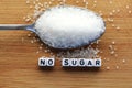 No sugar phrase made from plastic letter cubes placed in a spoon full of sugar