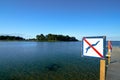 A no swimming danger sign on a wooden pier somewhere in Europe.