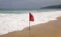 No Swimming Here red flag on a beach in Phuket, Thailand. The warning inscription is in the English, Thai and Russian languages Royalty Free Stock Photo