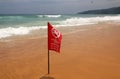 No Swimming Here red flag on a beach in Phuket, Thailand. The warning inscription is in the English, Thai and Russian languages Royalty Free Stock Photo