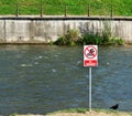 No swimming warning sign on a river bank